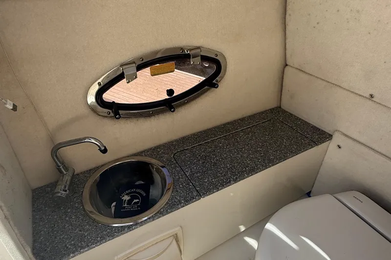 Slide: The Image of 2016 Chaparral 230 Suncoast boat interior with sink and porthole window. - 35