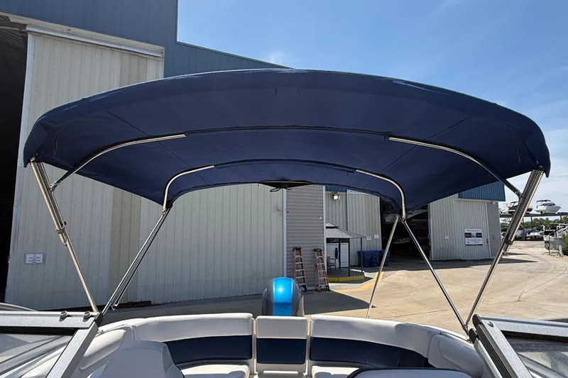 Slide: The Image of 2016 Chaparral 230 Suncoast boat with blue bimini top in marina setting. - 37