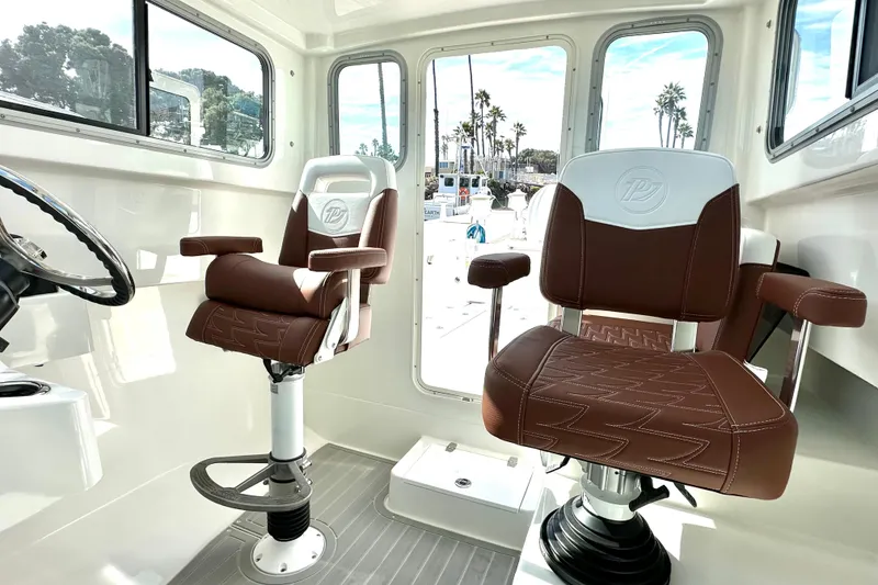 Slide: The Image of Interior of 2025 Parker 2420 Sport Cabin with brown leather seats and steering wheel. - 3