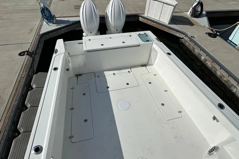Slide: The Image of 2025 Parker 2420 Sport Cabin boat deck at dock, featuring spacious layout and twin engines. - 7