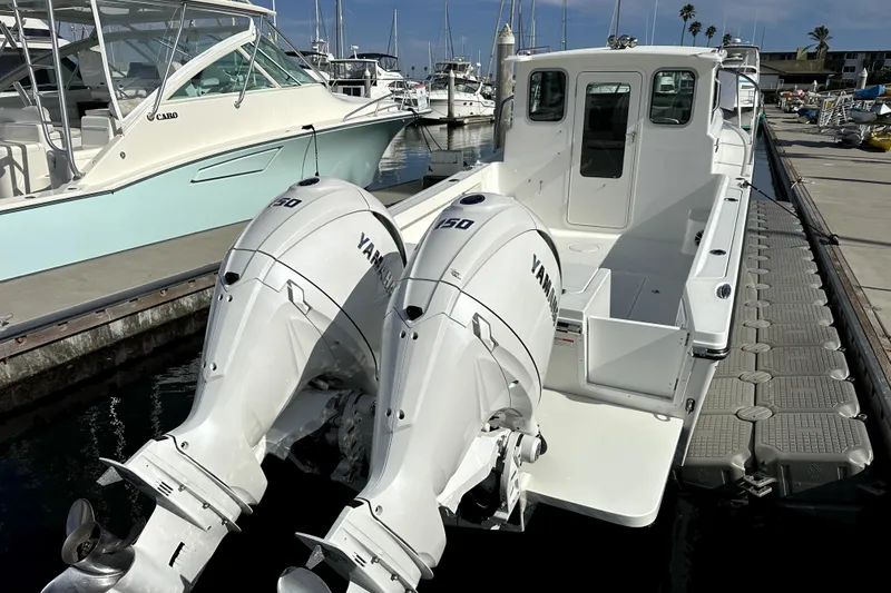 Slide: The Image of 2025 Parker 247 Explorer boat with twin Yamaha engines docked at marina. - 8