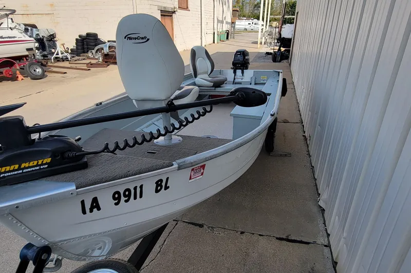 Slide: The Image of 2014 MirroCraft 1400 boat with Minn Kota motor, parked on a trailer. - 10