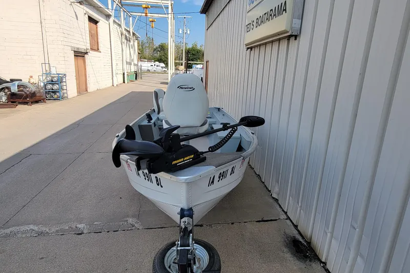 Slide: The Image of 2014 MirroCraft 1400 boat on trailer, parked beside a building. - 11