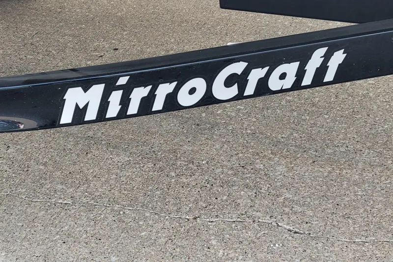 Slide: The Image of MirroCraft 1400 boat trailer, 2014 model, black with white lettering on concrete surface. - 4
