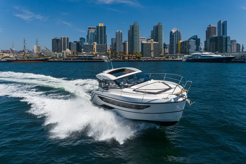 Slide: The Image of 2024 Bavaria SR38 yacht cruising in a city harbor with skyline backdrop. - 10