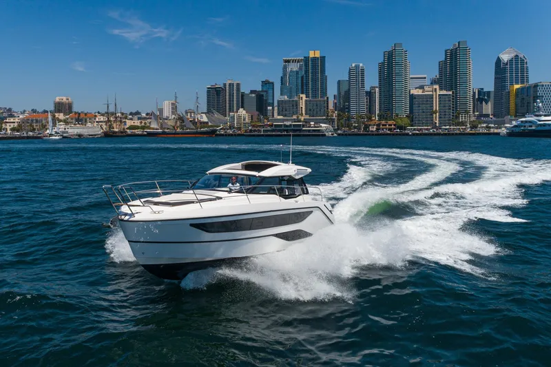 Slide: The Image of 2024 Bavaria SR38 yacht cruising in front of a city skyline on a sunny day. - 12