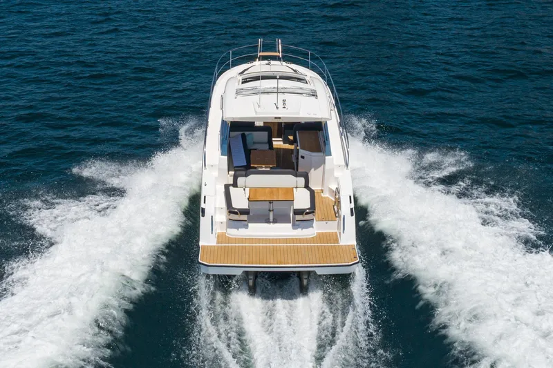 Slide: The Image of 2024 Bavaria SR38 yacht cruising on open water, rear view showcasing deck and wake. - 16