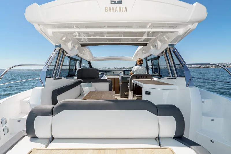 Slide: The Image of 2024 Bavaria SR38 yacht interior with seating, table, and ocean view. - 19