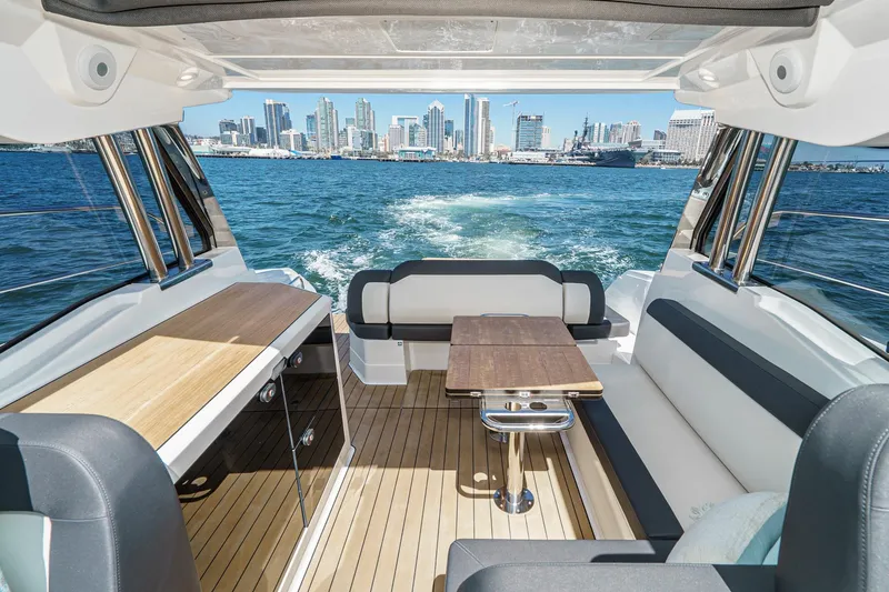 Slide: The Image of 2024 Bavaria SR38 yacht interior with city skyline view, featuring sleek seating and table. - 20