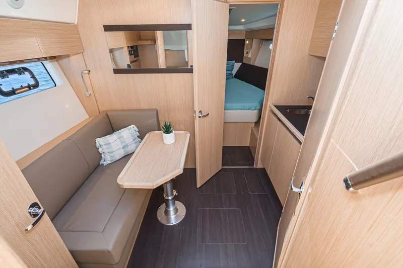 Slide: The Image of 2024 Bavaria SR38 yacht interior with seating, table, and cabin view. - 33