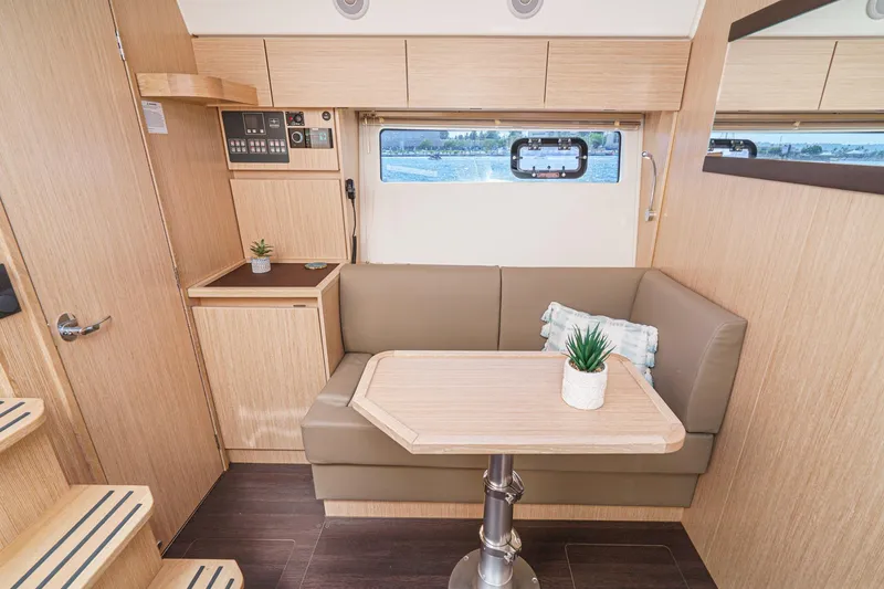 Slide: The Image of 2024 Bavaria SR38 yacht interior with cozy seating and table, modern design. - 34