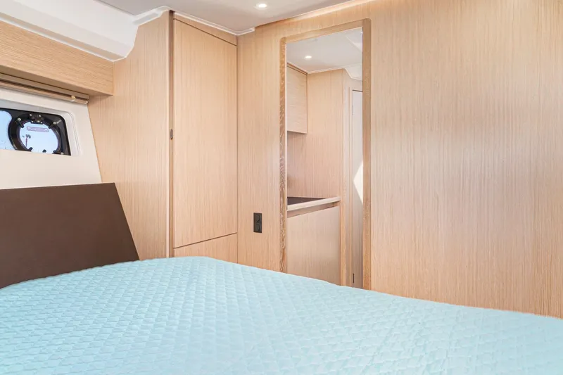 Slide: The Image of 2024 Bavaria SR38 yacht interior with modern wood finish and cozy bedding. - 41