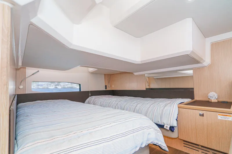 Slide: The Image of 2024 Bavaria SR38 yacht cabin with twin beds, modern design, and natural wood accents. - 44