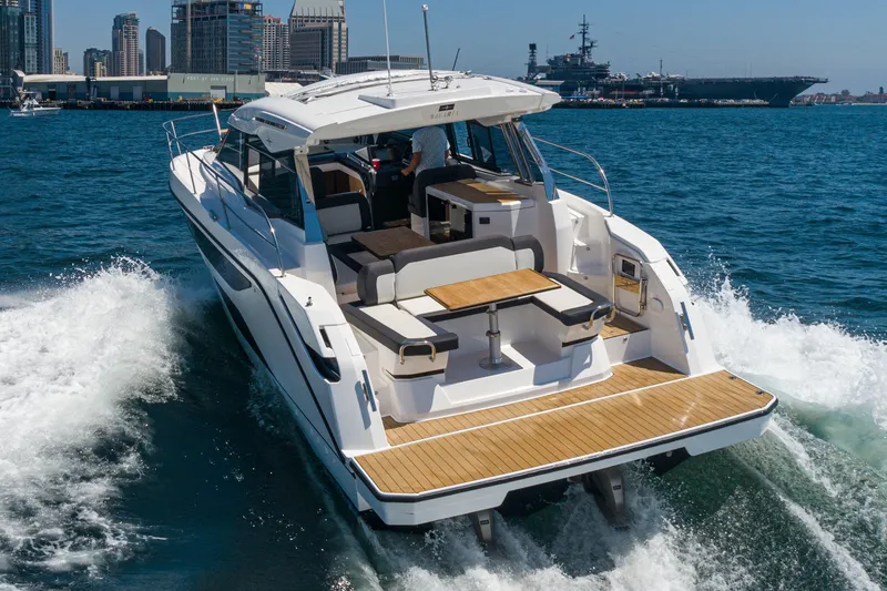 Slide: The Image of 2024 Bavaria SR38 yacht cruising in a harbor with city skyline backdrop. - 6