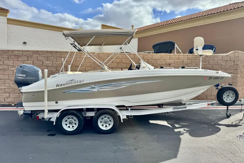 The Image of 2013 NauticStar 203 SC boat on trailer, featuring Yamaha outboard motor. - 0