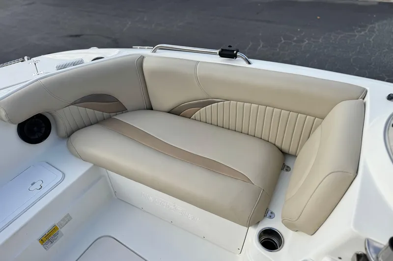Slide: The Image of 2013 NauticStar 203 SC boat interior with beige cushioned seating and cup holder. - 14