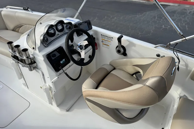 Slide: The Image of 2013 NauticStar 203 SC boat cockpit with steering wheel and beige seating. - 28