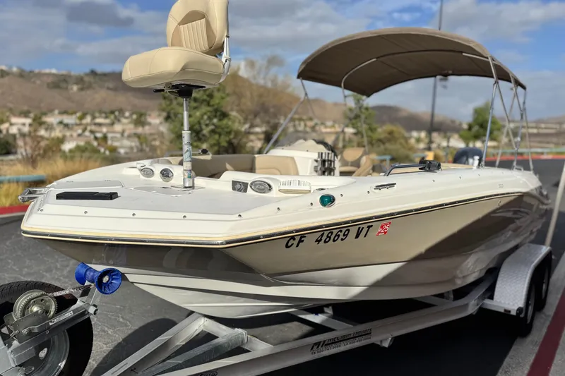 Slide: The Image of 2013 NauticStar 203 SC boat on trailer, featuring a beige seat and canopy. - 3