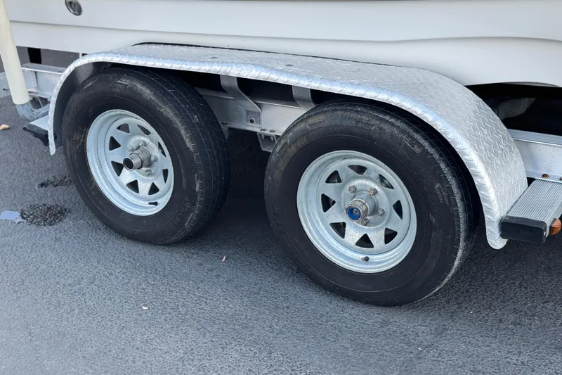 Slide: The Image of Trailer wheels of a 2013 NauticStar 203 SC boat on asphalt surface. - 33