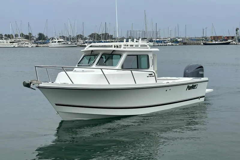 The Image of 2026 Parker 227 Explorer boat on trailer, parked outdoors under clear blue sky. - 0