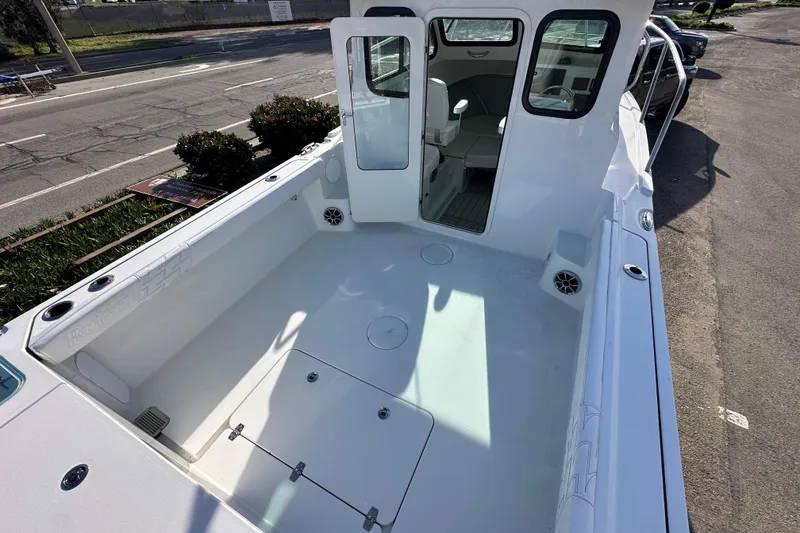 Slide: The Image of 2026 Parker 227 Explorer boat with spacious deck and cabin, parked outdoors. - 10