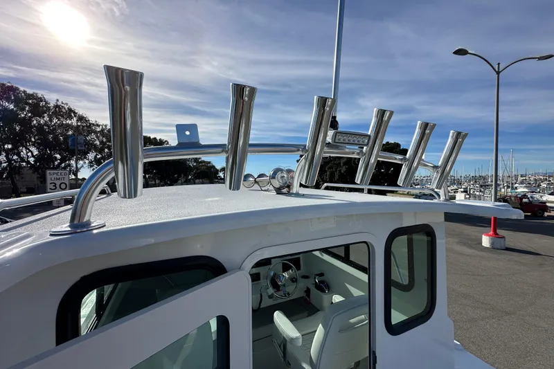 Slide: The Image of Parker 227 Explorer 2026 boat with rod holders, docked under a clear sky. - 8