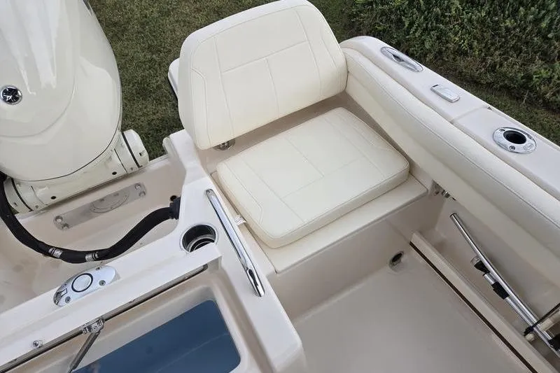 Slide: The Image of 2026 Grady-White Freedom 215 boat interior with cushioned seating and motor detail. - 11
