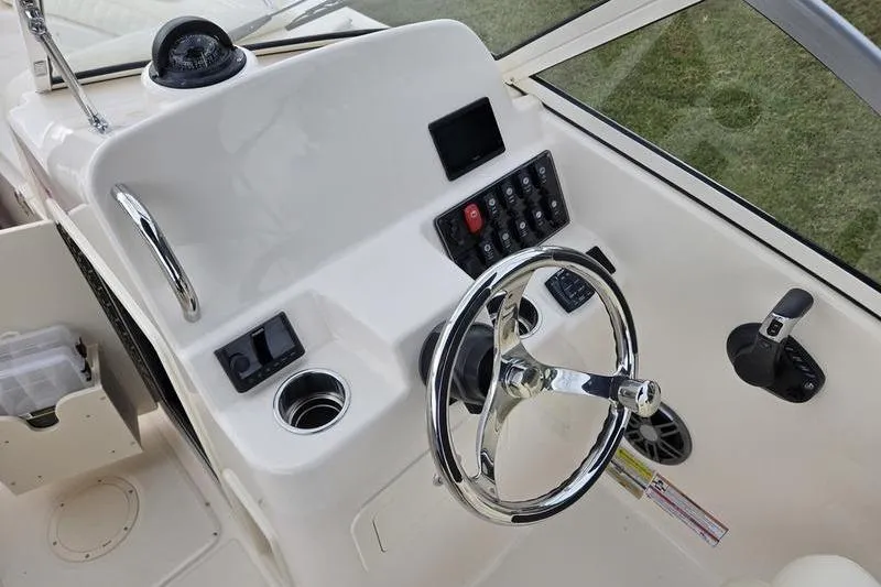 Slide: The Image of 2026 Grady-White Freedom 215 boat dashboard with steering wheel and control panel. - 12