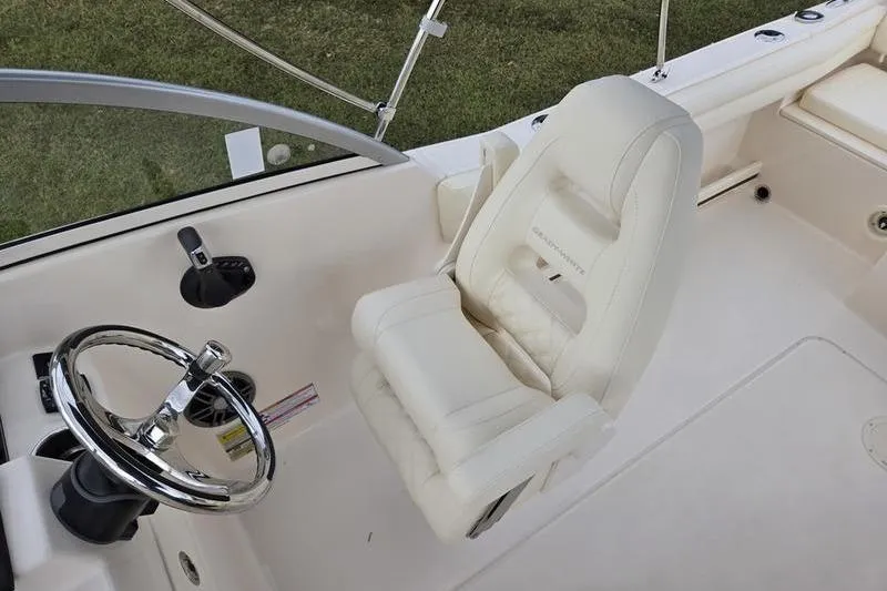 Slide: The Image of 2026 Grady-White Freedom 215 boat interior with steering wheel and plush captain's chair. - 13