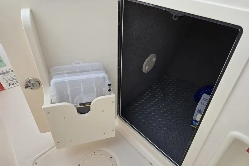 Slide: The Image of 2026 Grady-White Freedom 215 storage compartment with organizer and diamond-patterned flooring. - 15