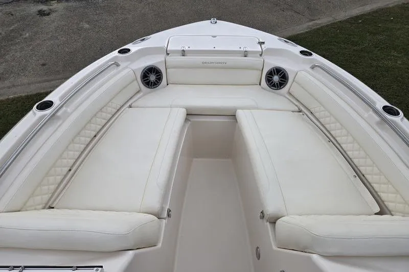 Slide: The Image of 2026 Grady-White Freedom 215 boat interior with white cushioned seating and speakers. - 7