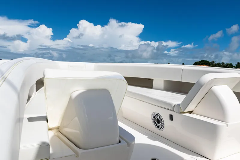Slide: The Image of 2023 SeaVee 340Z boat interior with white seating under a clear blue sky. - 15