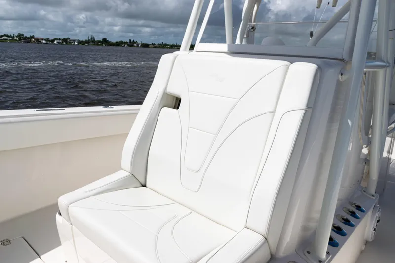 Slide: The Image of 2023 SeaVee 340Z boat with white cushioned seating, on a calm water backdrop. - 18