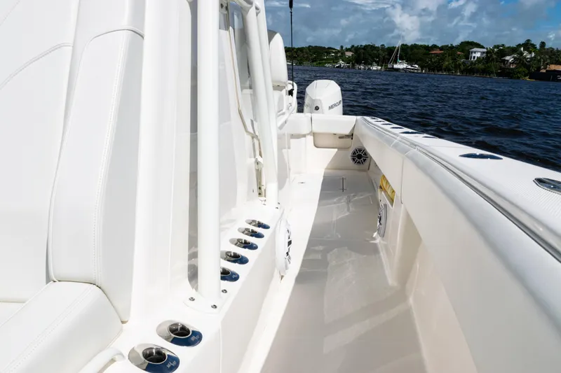 Slide: The Image of 2023 SeaVee 340Z boat interior with white seating and cup holders, on a sunny day. - 22