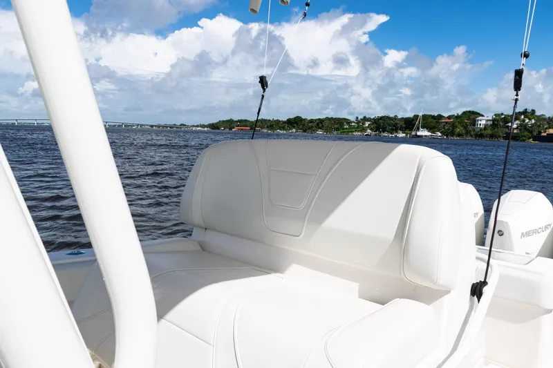 Slide: The Image of 2023 SeaVee 340Z boat interior with white seating, on a sunny day by the water. - 24