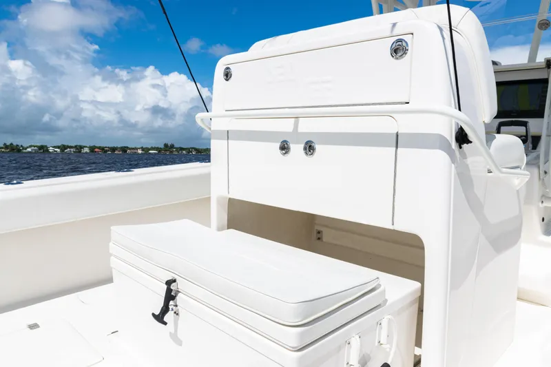 Slide: The Image of 2023 SeaVee 340Z boat interior with storage compartment and cooler, under a clear blue sky. - 33