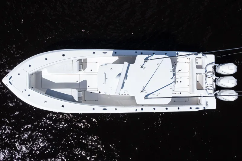 Slide: The Image of Overhead view of 2023 SeaVee 340Z boat with triple outboard engines on dark water. - 47