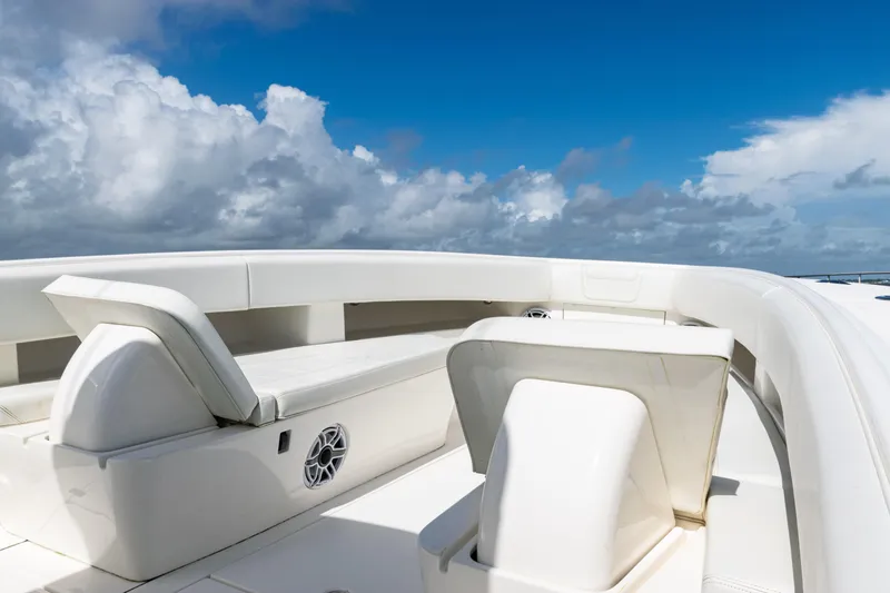Slide: The Image of 2023 SeaVee 340Z boat interior with white seating under a blue sky. - 8