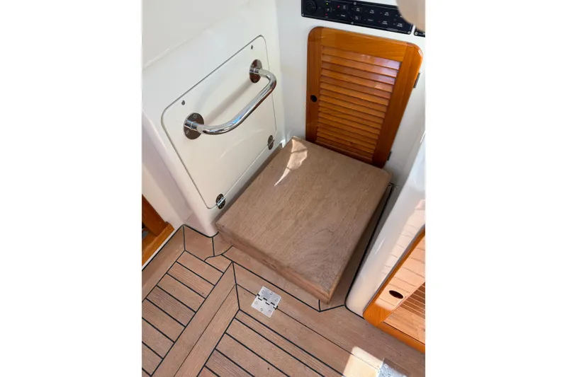 Slide: The Image of 2003 Hinckley Talaria 40 interior with wooden flooring and storage compartments. - 10