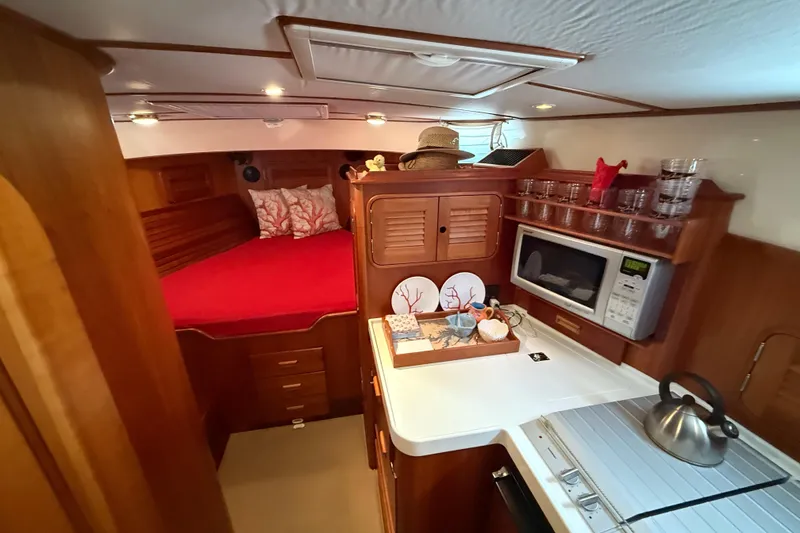 Slide: The Image of Cozy interior of 2003 Hinckley Talaria 40 yacht with bed, kitchenette, and microwave. - 11