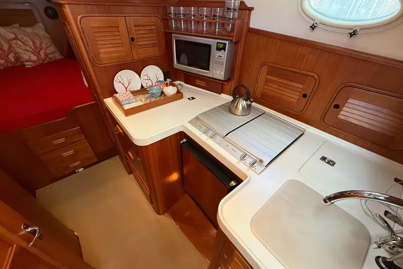 Slide: The Image of Luxurious 2003 Hinckley Talaria 40 yacht kitchen with wood cabinetry and modern appliances. - 13