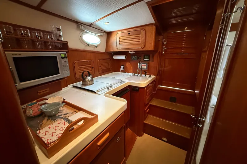 Slide: The Image of Luxurious 2003 Hinckley Talaria 40 yacht kitchen with wood cabinetry and modern appliances. - 14
