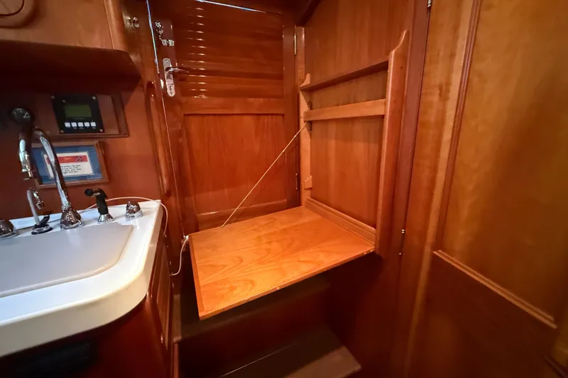 Slide: The Image of 2003 Hinckley Talaria 40 interior with wooden cabinetry and compact sink area. - 18