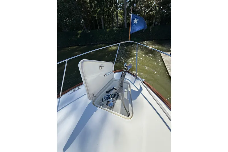 Slide: The Image of 2003 Hinckley Talaria 40 yacht bow with open anchor hatch and flag. - 22