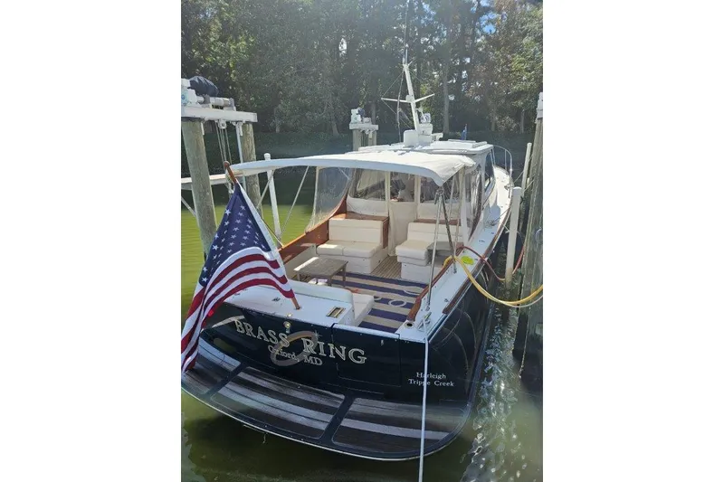 Slide: The Image of 2003 Hinckley Talaria 40 yacht docked, displaying an American flag and elegant seating. - 27