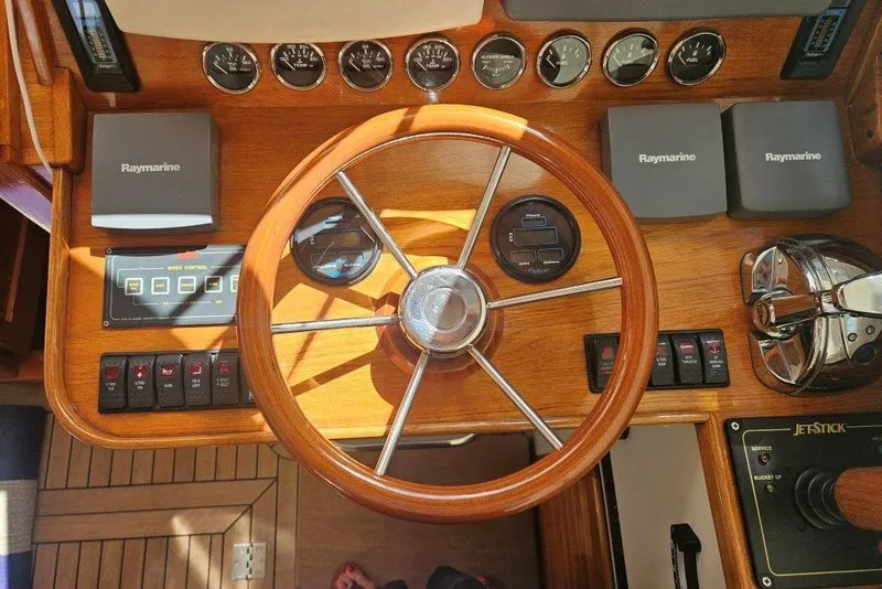 Slide: The Image of Helm of 2003 Hinckley Talaria 40 with wooden steering wheel and Raymarine electronics. - 8