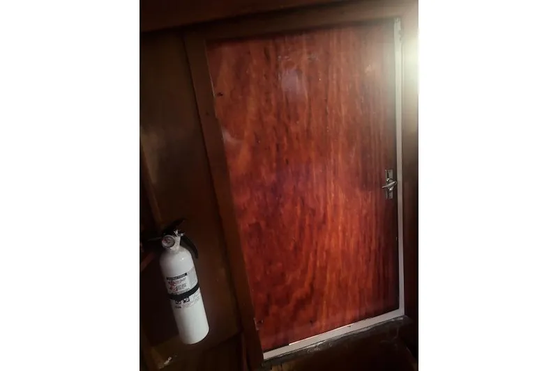 Slide: The Image of Wooden cabin door with fire extinguisher, Marine Trading Tri-Cabin 44, 1978 model. - 20