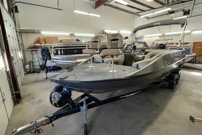 Slide: The Image of 2021 Lowe Sport Deck 224 boat displayed in a showroom, featuring sleek design and modern seating. - 1