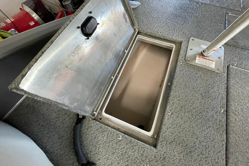 Slide: The Image of 2021 Lowe Sport Deck 224 storage compartment with open lid and key lock. - 17