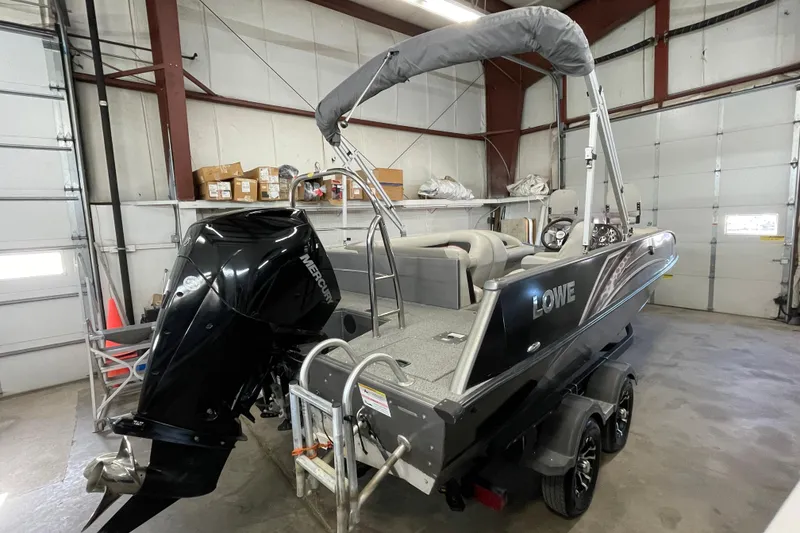 Slide: The Image of 2021 Lowe Sport Deck 224 boat with Mercury engine in showroom. - 2